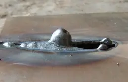 Foto de perfuração na raiz da solda com metal fundido formando um furo